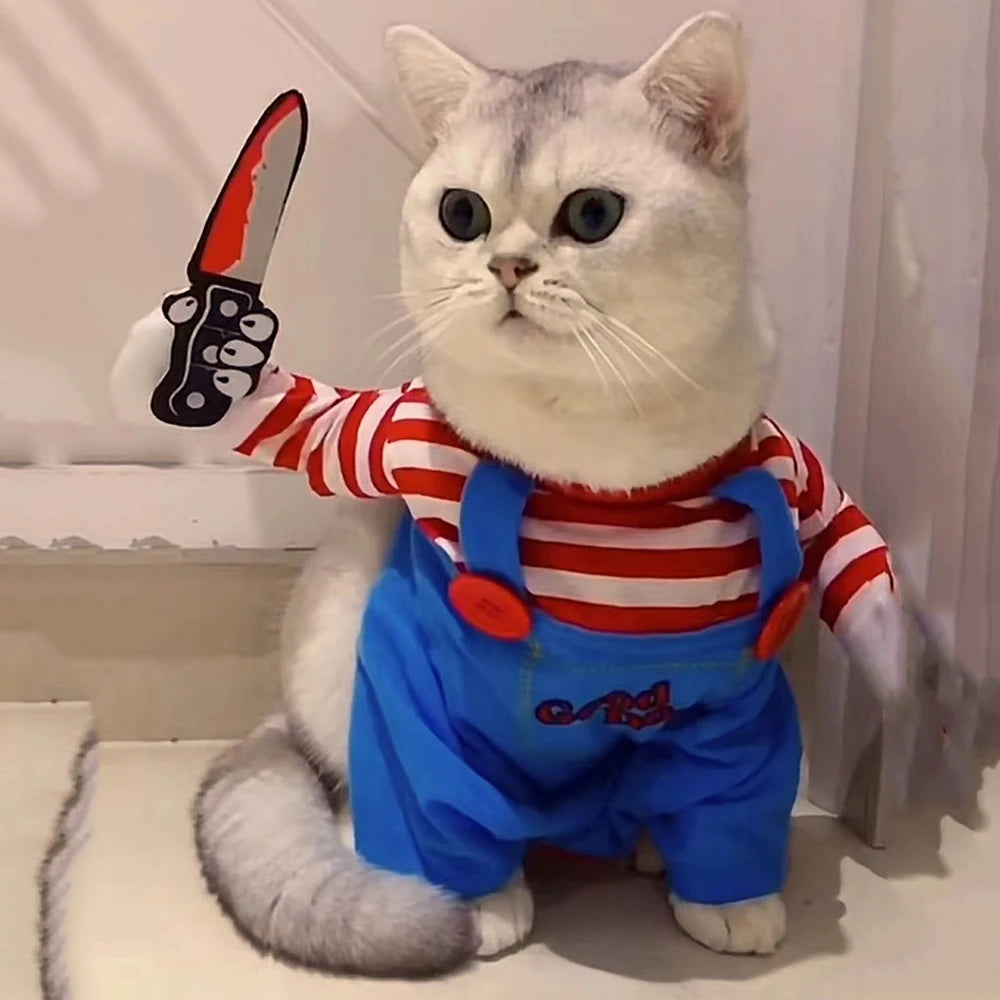 Cat wearing a costume with red and white striped shirt and blue overalls, holding a toy sword.