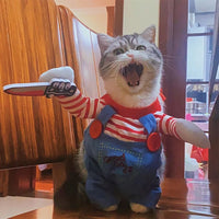 Cat in a costume with a toy knife, standing indoors.
