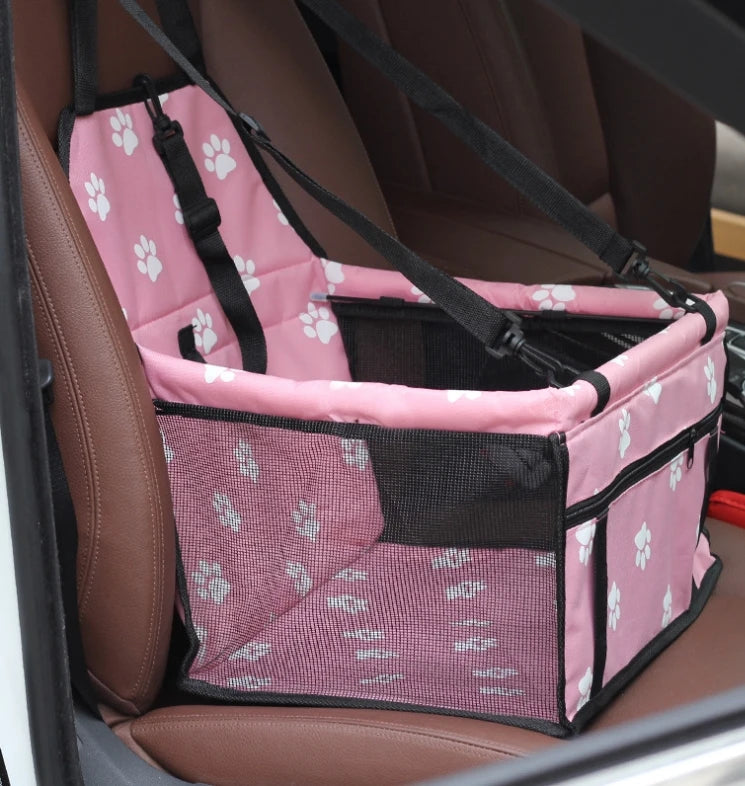 Pink pet seat cover with paw prints on a car seat