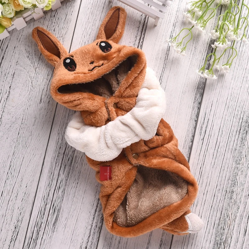 Plush toy resembling a fox with a white scarf on a wooden surface
