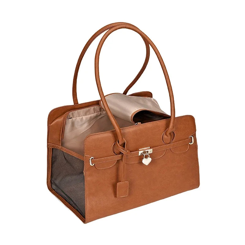 Brown leather pet carrier with a beige interior on a white background