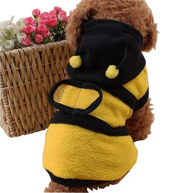Dog wearing a bee-themed costume with a basket of flowers in the background