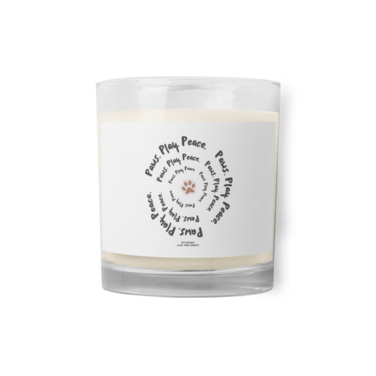 Clear glass candle with a white label featuring text and paw prints on a white background